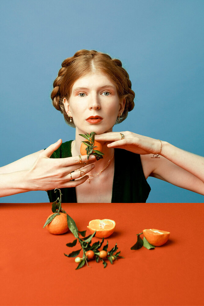 ginger woman posing with tangerines